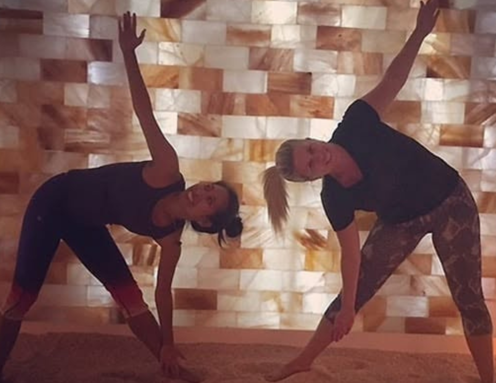 Group yoga class practicing in the Himalayan salt room at Salt Spa Haven in Fayetteville, Georgia.