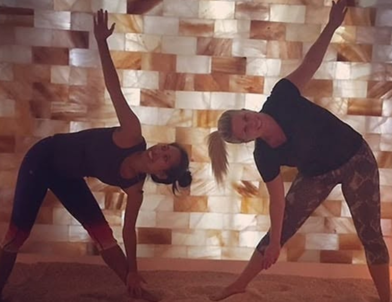 Group yoga class practicing in the Himalayan salt room at Salt Spa Haven in Fayetteville, Georgia.