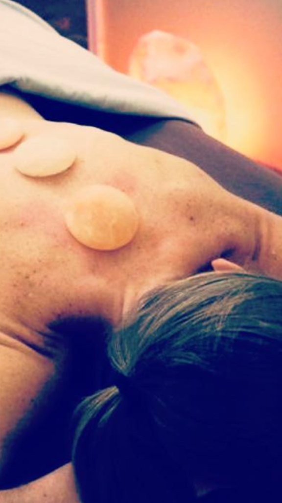 Hot stone massage treatment in the Himalayan salt room at Salt Spa Haven in Fayetteville, Georgia.